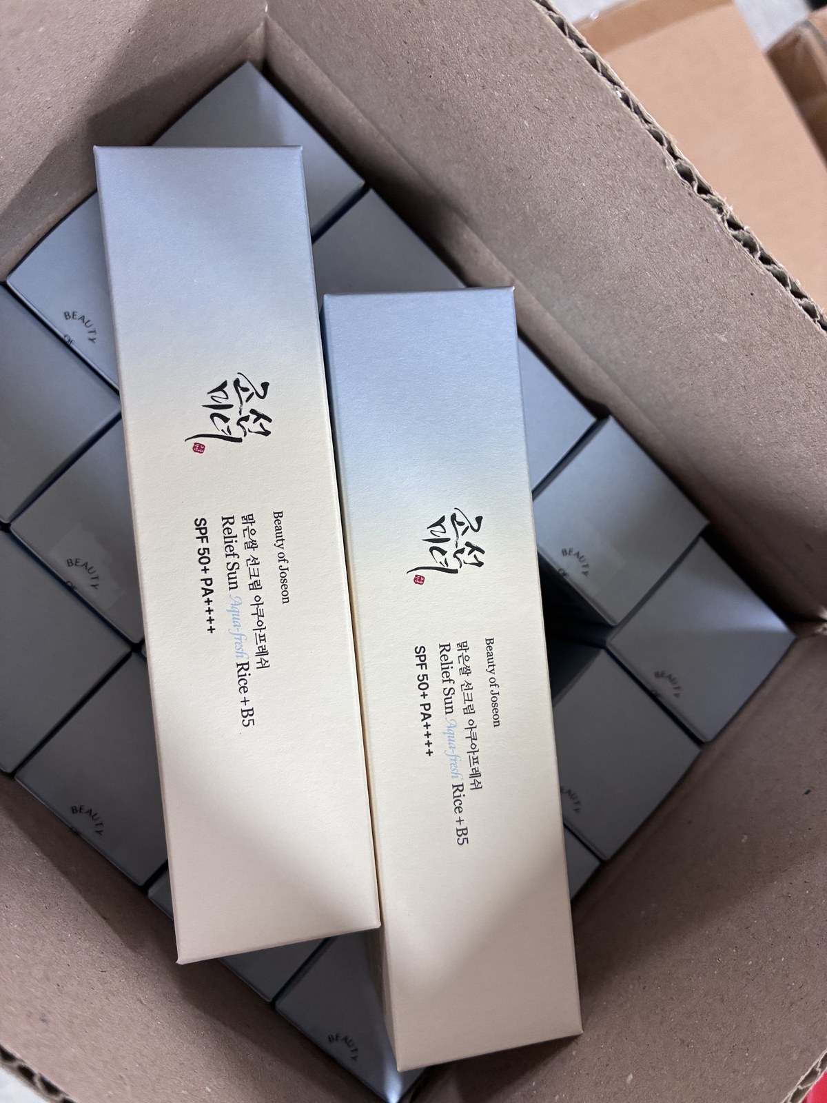 Two variants of the same Korean sun care line packed side by side in one shipment
