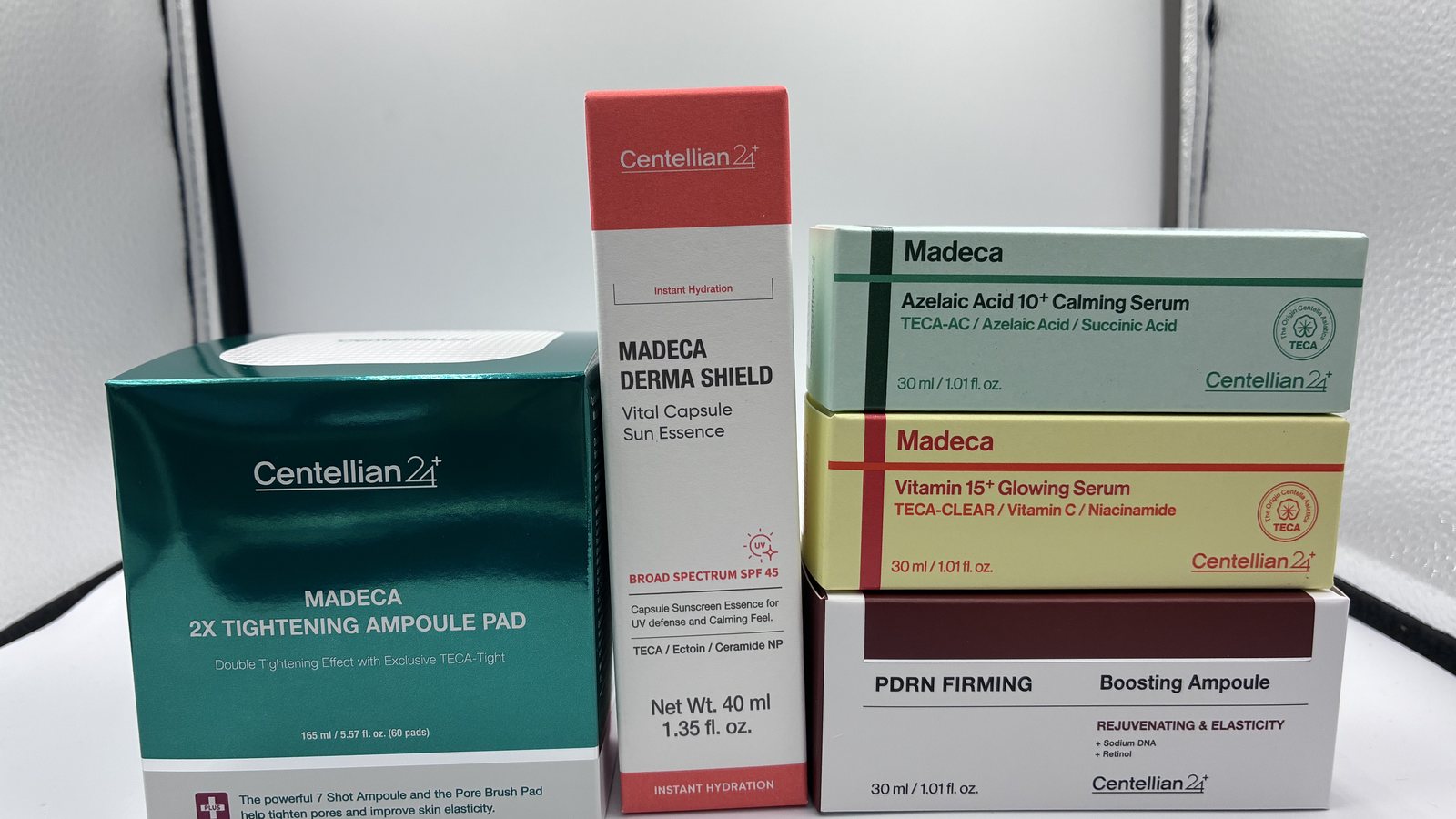 Five Centellian24 boxes including the SPF 45 sun essence beside four cosmetic-lane serums